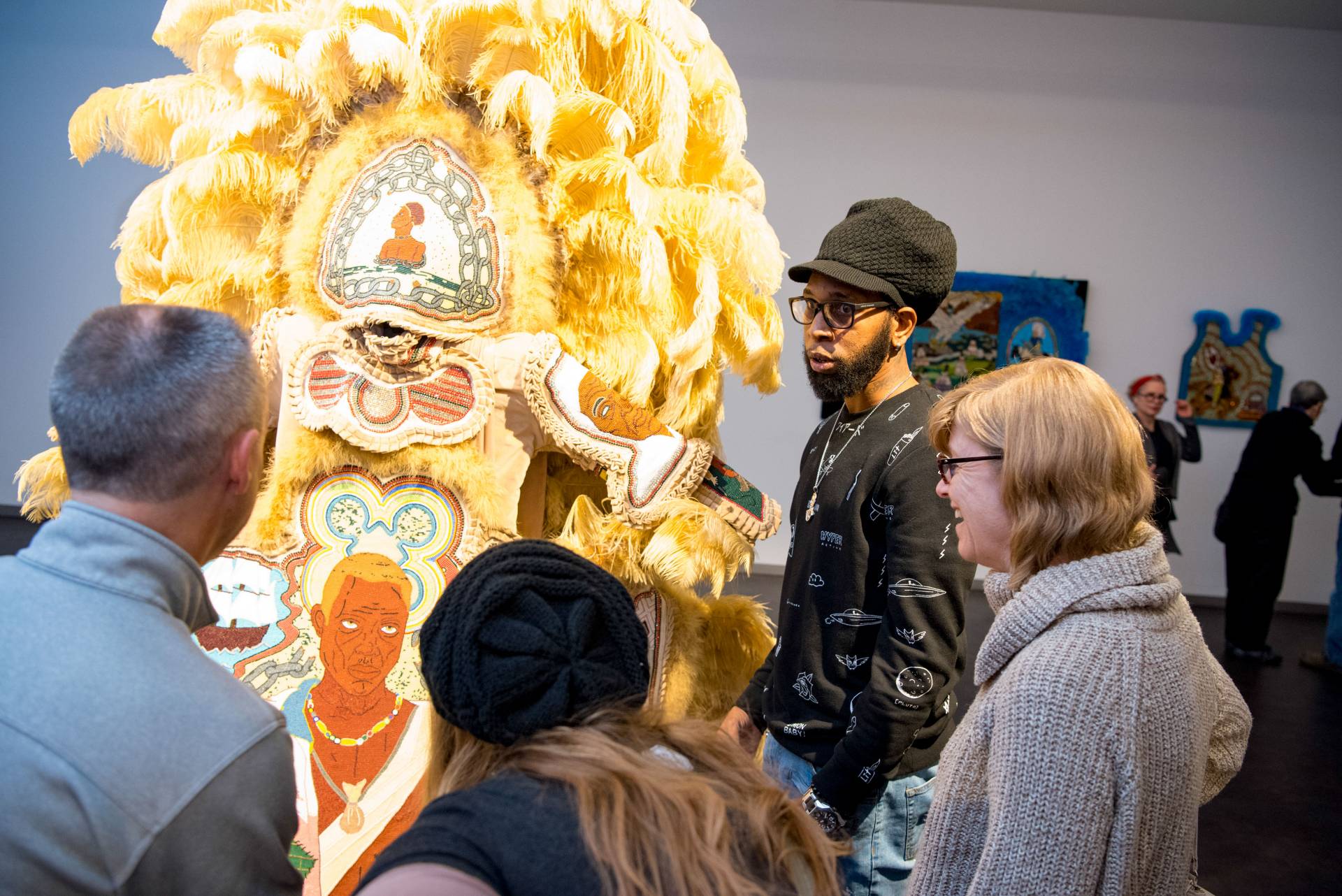 Big Chief Demond Melancon talking in front of his ceremonial suit