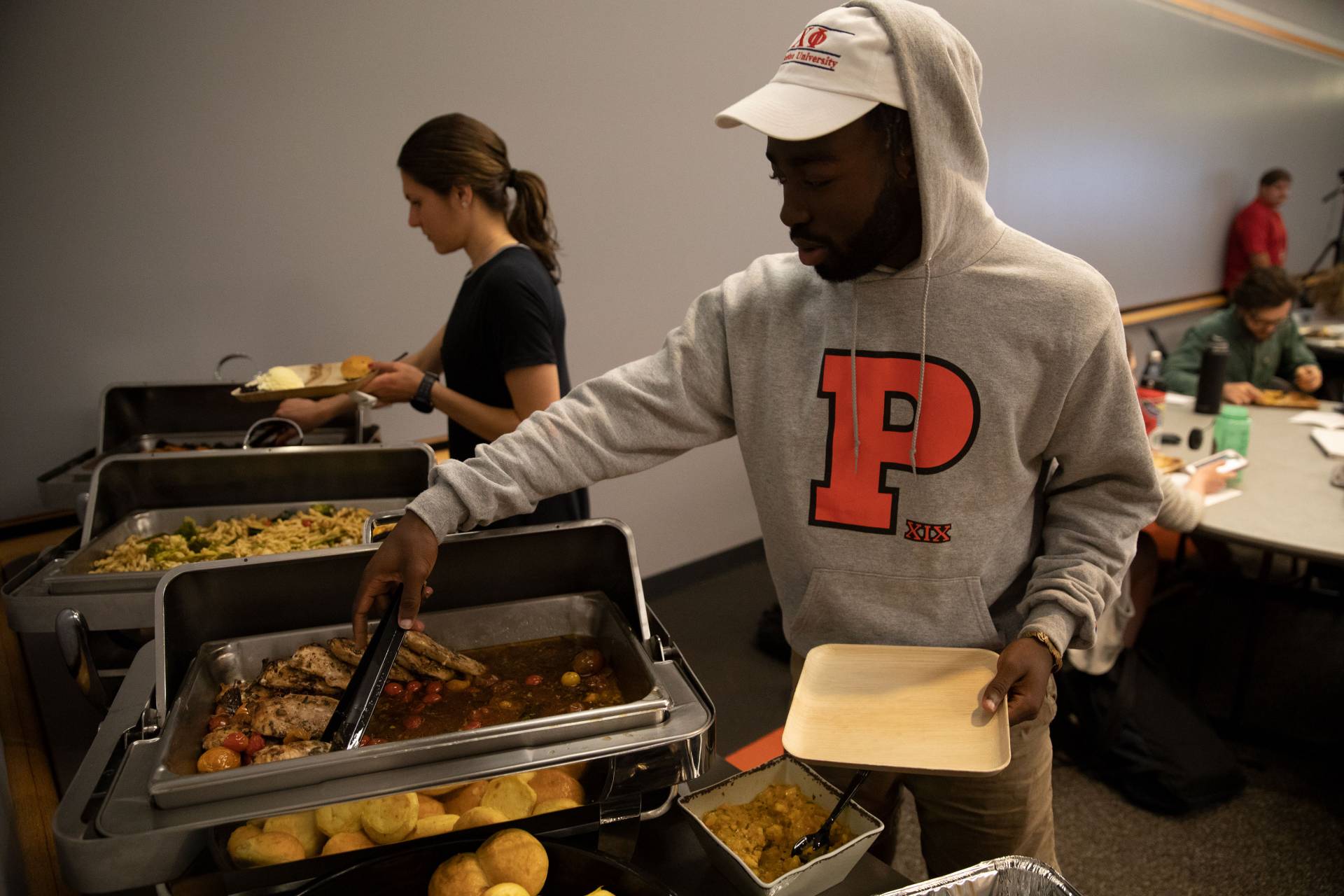 Temi Aladeseru ladling food onto his plate