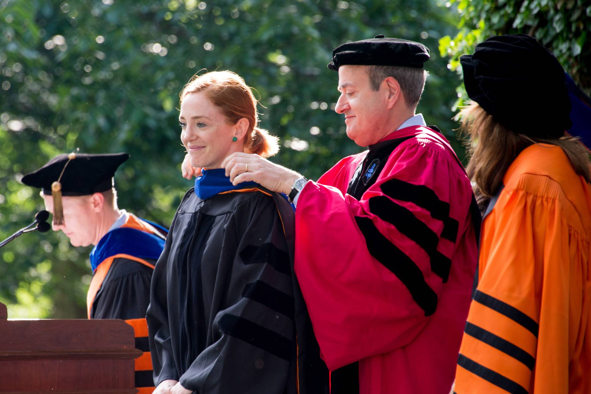 Student receives her hood from her adviser