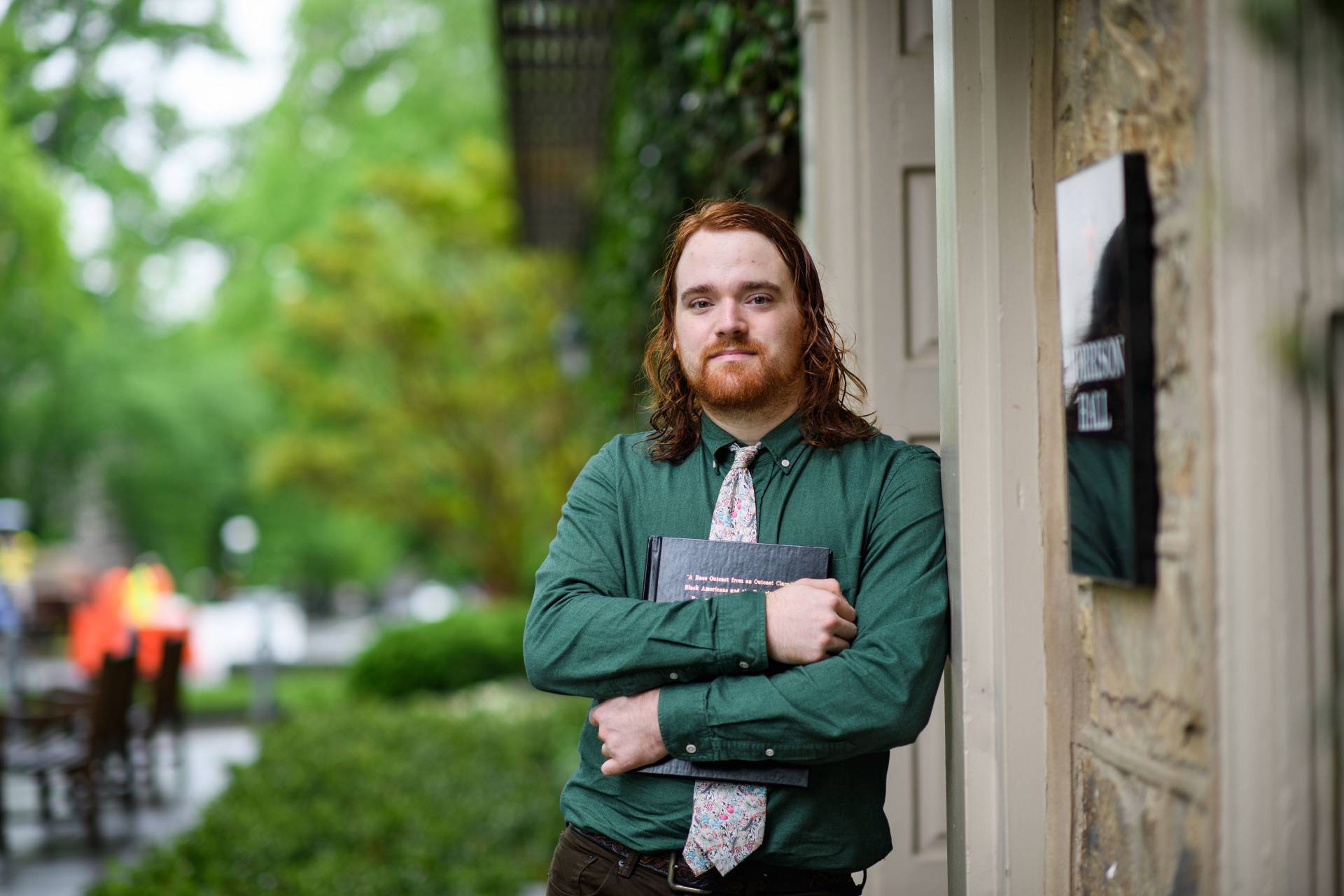 Nicky Steidel holding his senior thesis outside of Morrison Hall