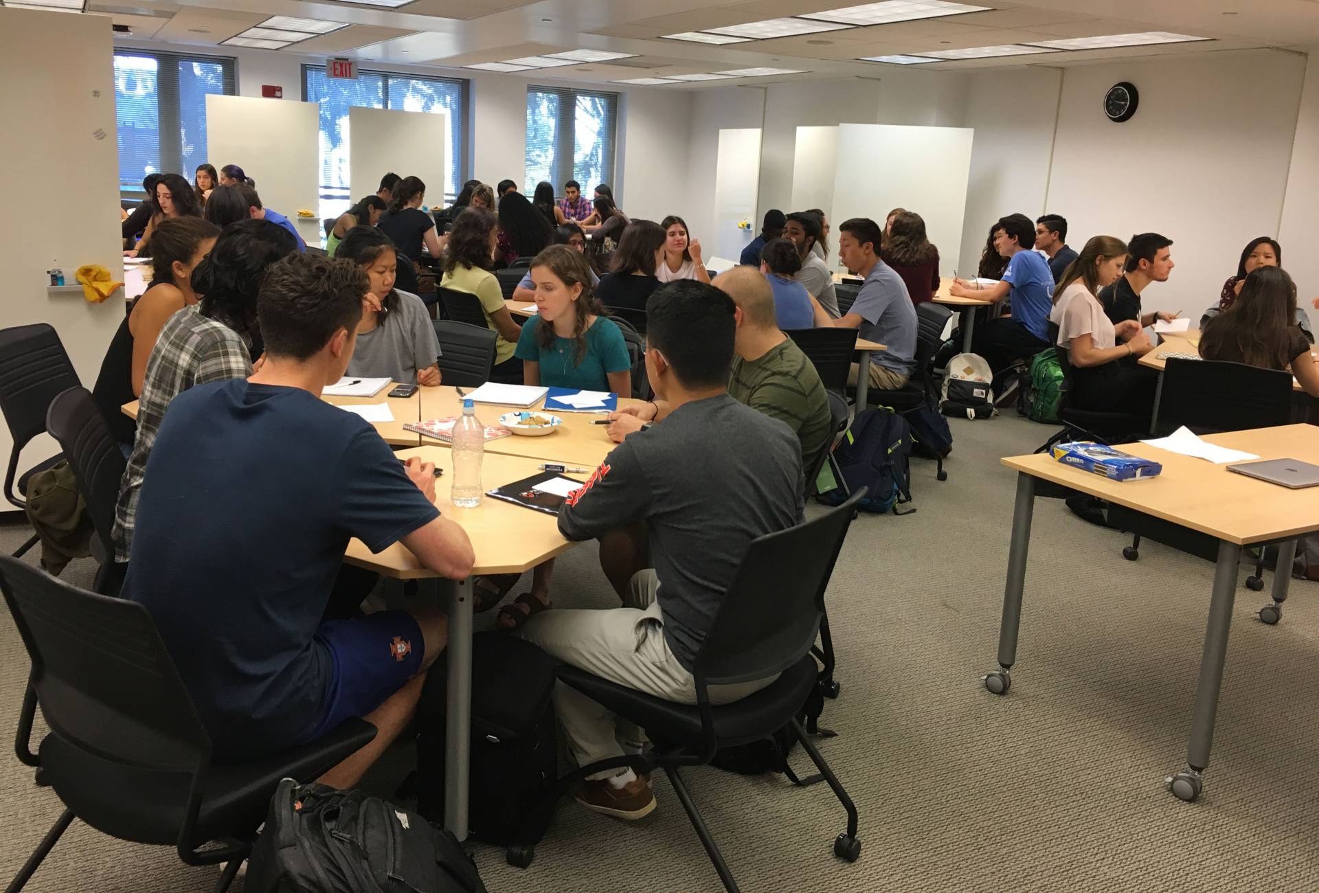 Students sitting at tabes in large classroom