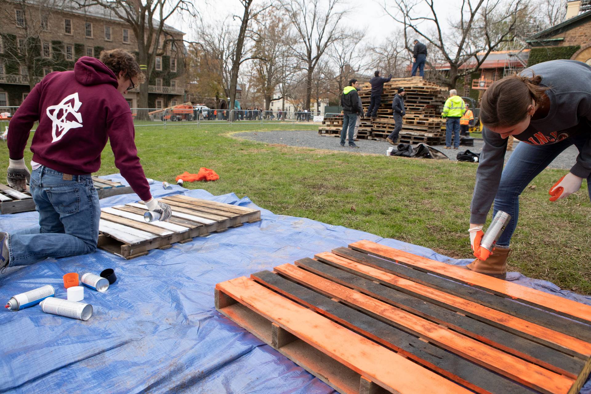 Students spraypaint planks for the bonfire