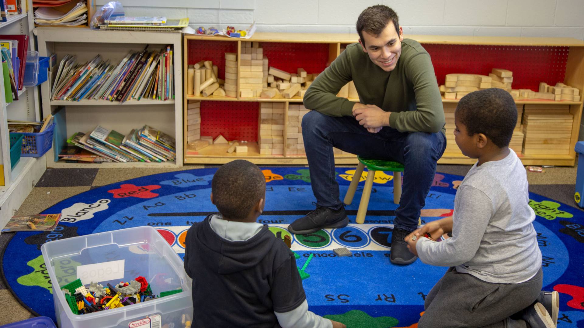 Student engaging with two elementary school children