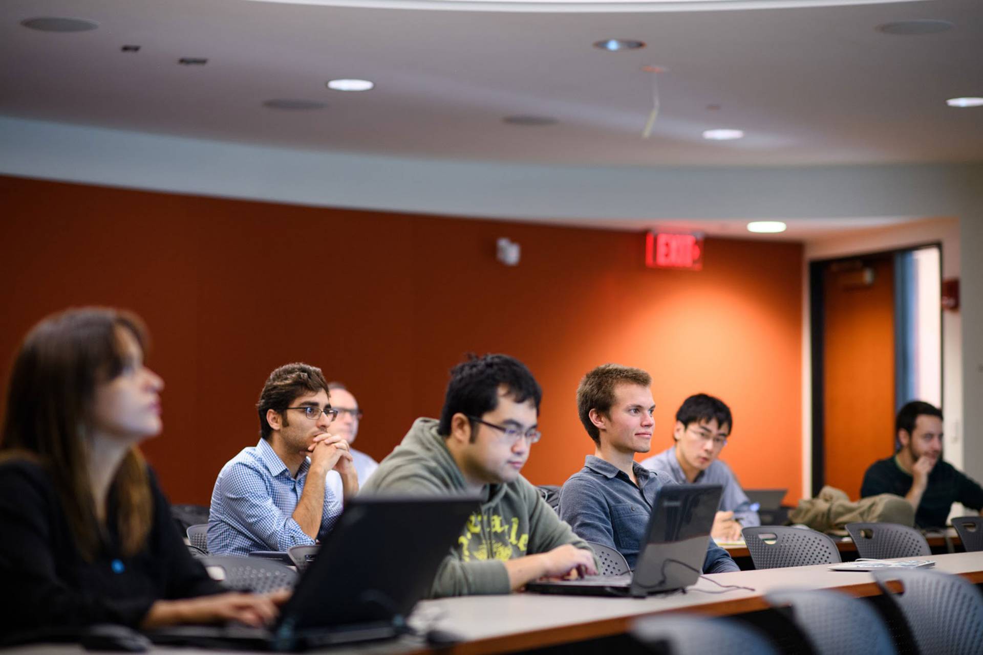 Graduate students sitting at desks with computers