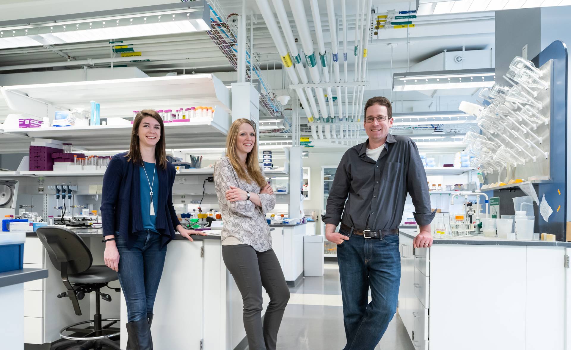 Allison Murawski, Theresa Barrett  and Mark Brynildsen standing in a lab