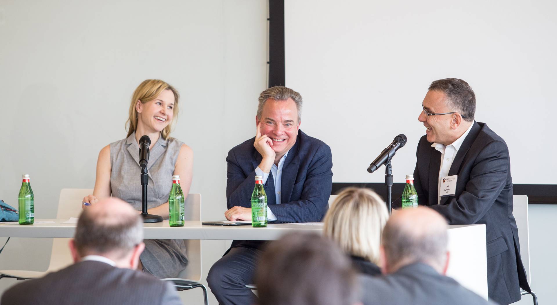 Three experts speak on a panel in front of an audience