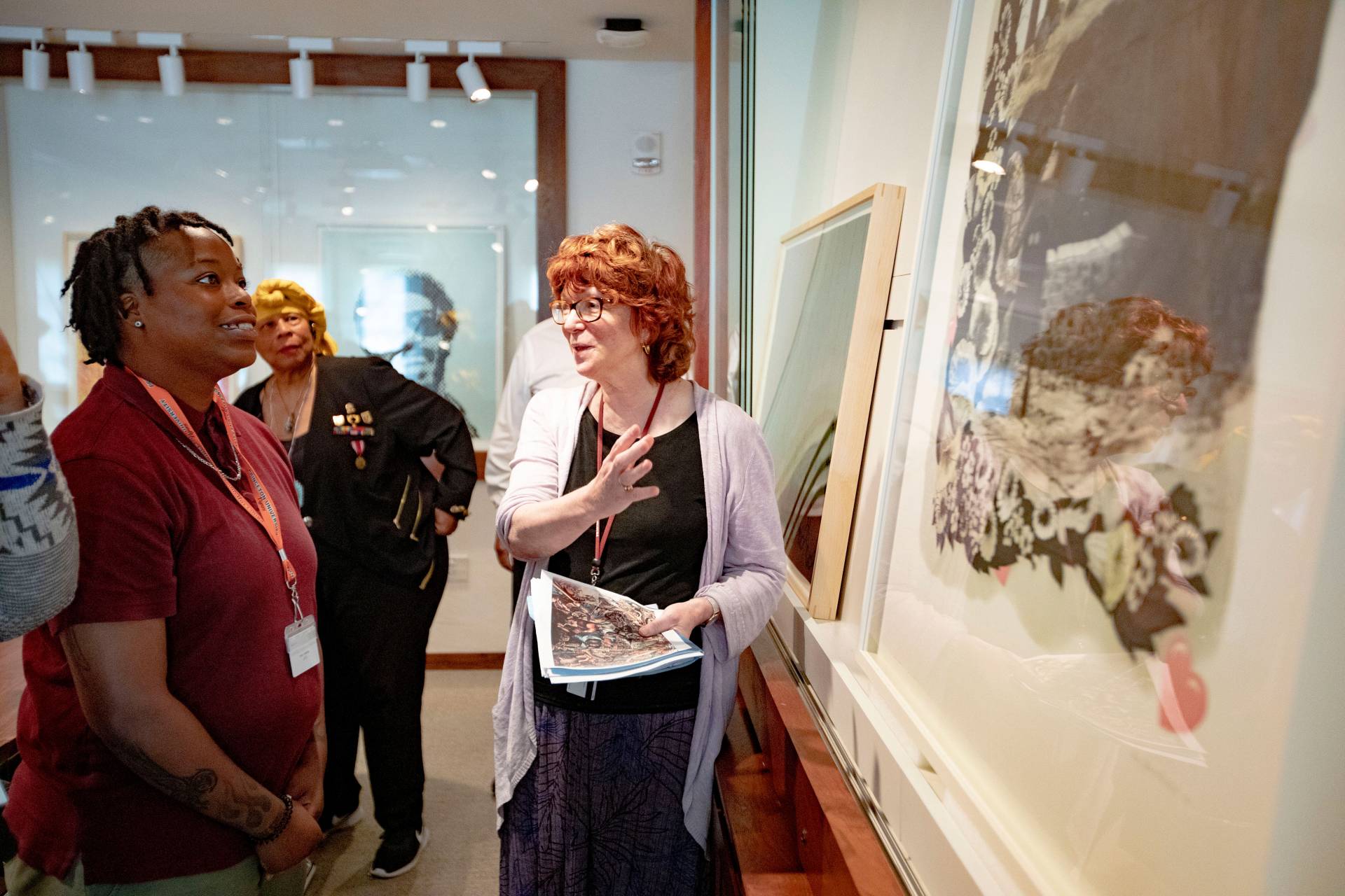 A student and a curator talk about a work of art on a wall