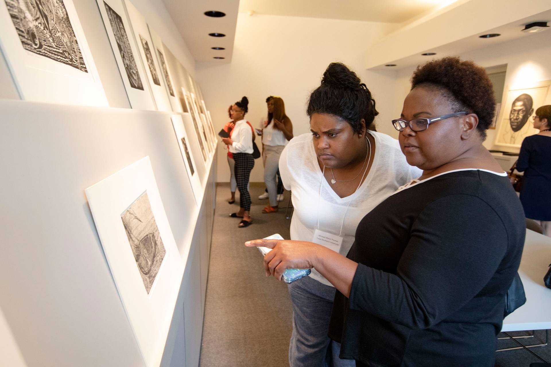 Two women discussing a work of art on paper