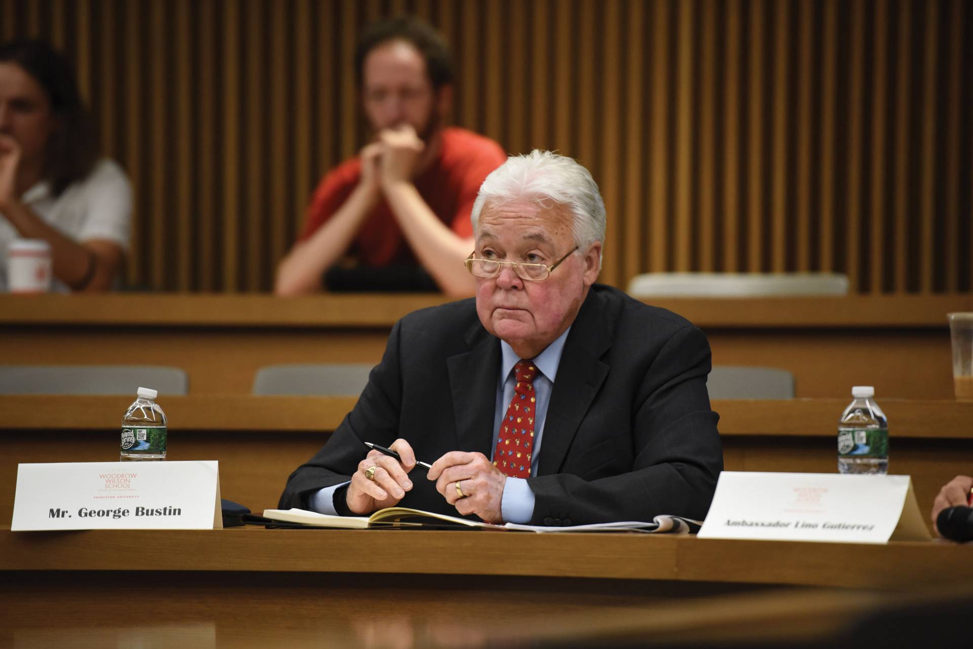 George Bustin listens to presentations in a classroom