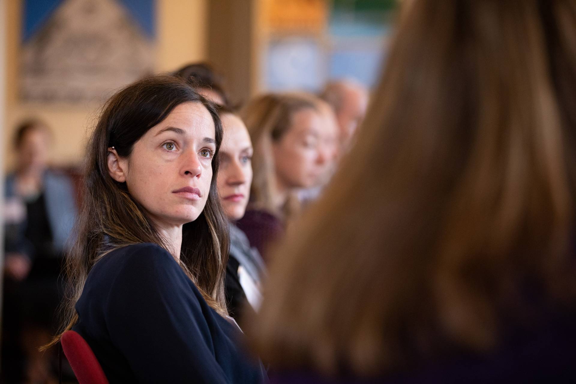 Faculty listen intently while sitting around a table