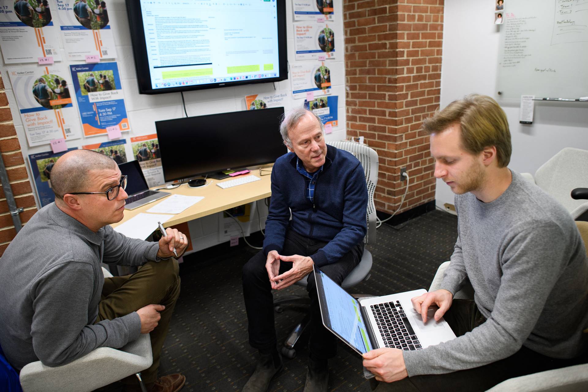 3 men sit across from each other