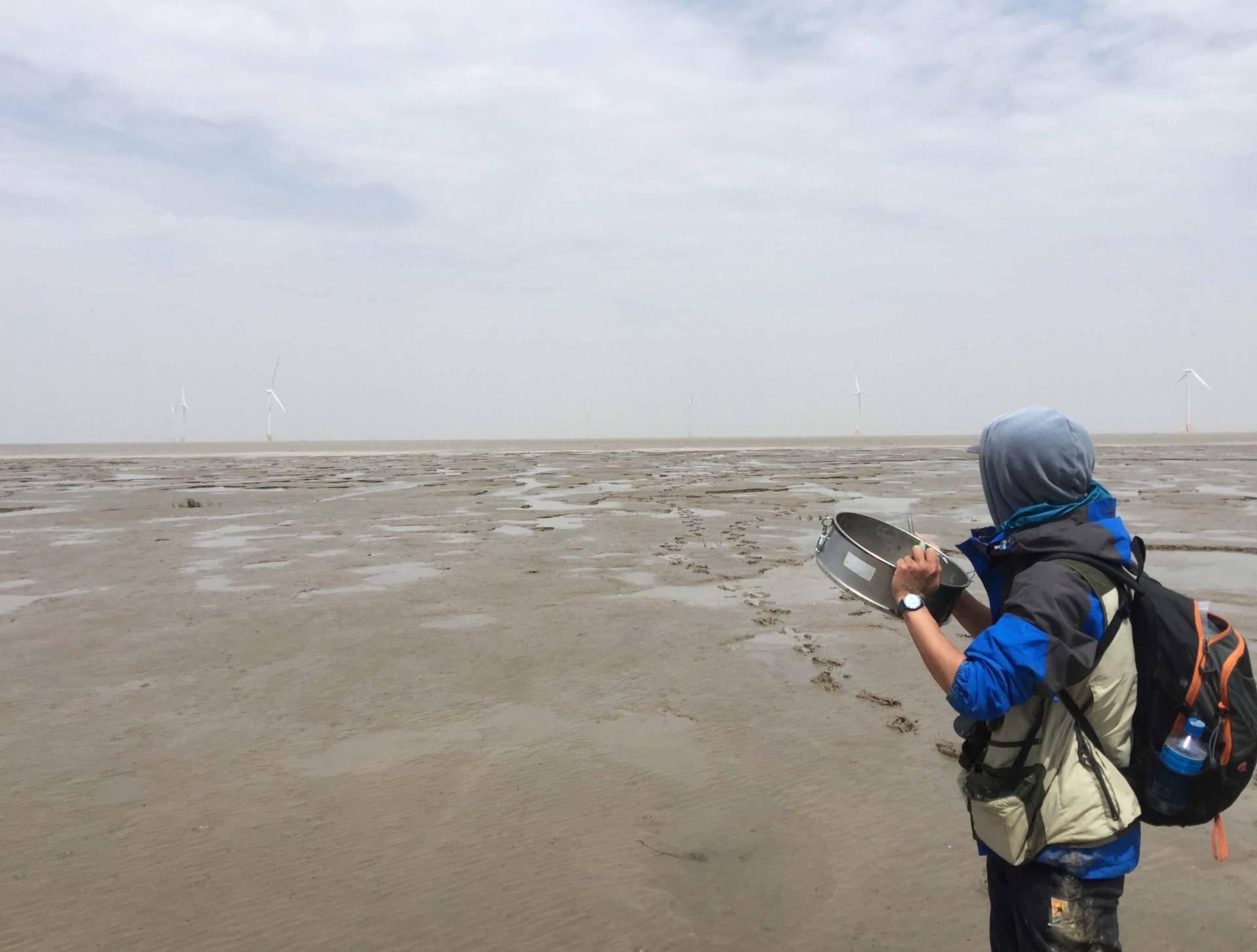 Tong Mu on a beach at low tide, gathering data