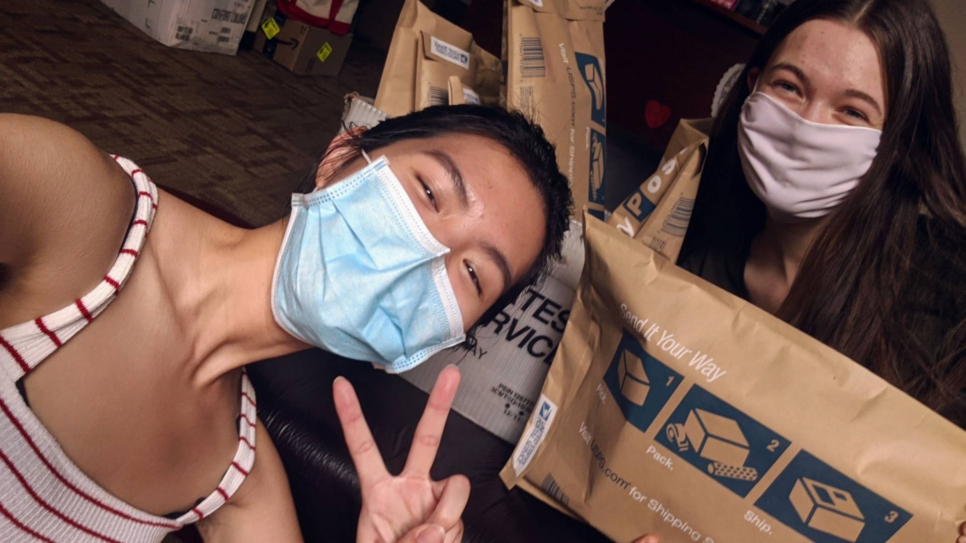 2 people pose in front of packages