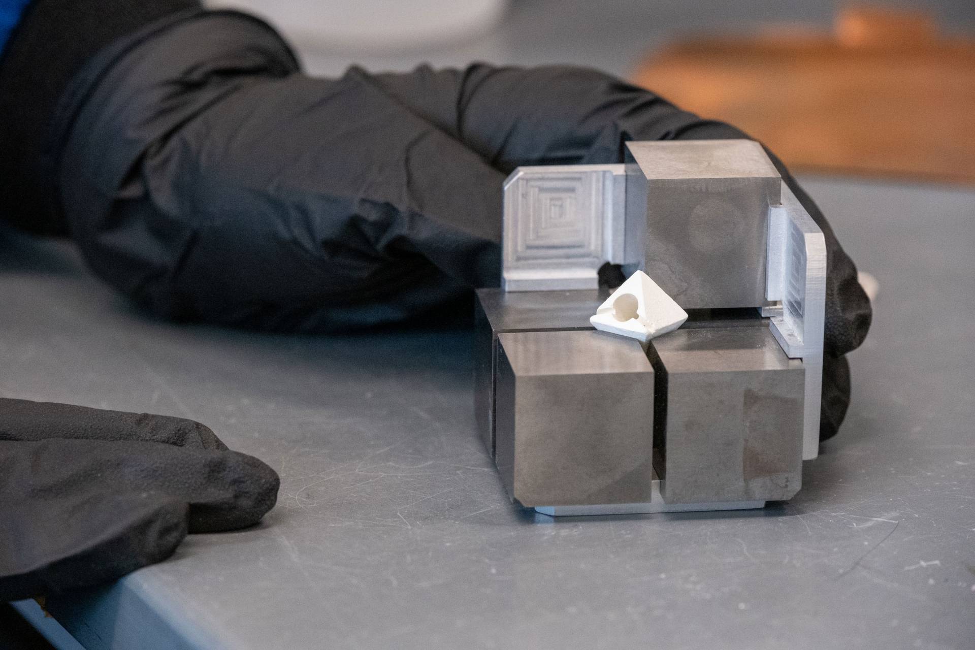 black gloved hands and metal cubes