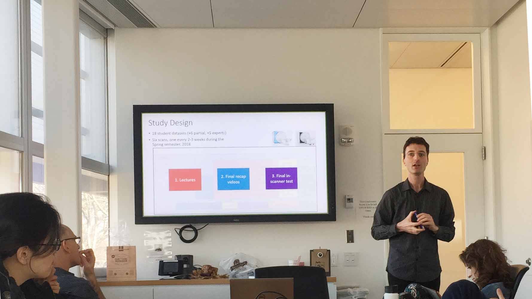 A person makes a presentation in front of a large screen