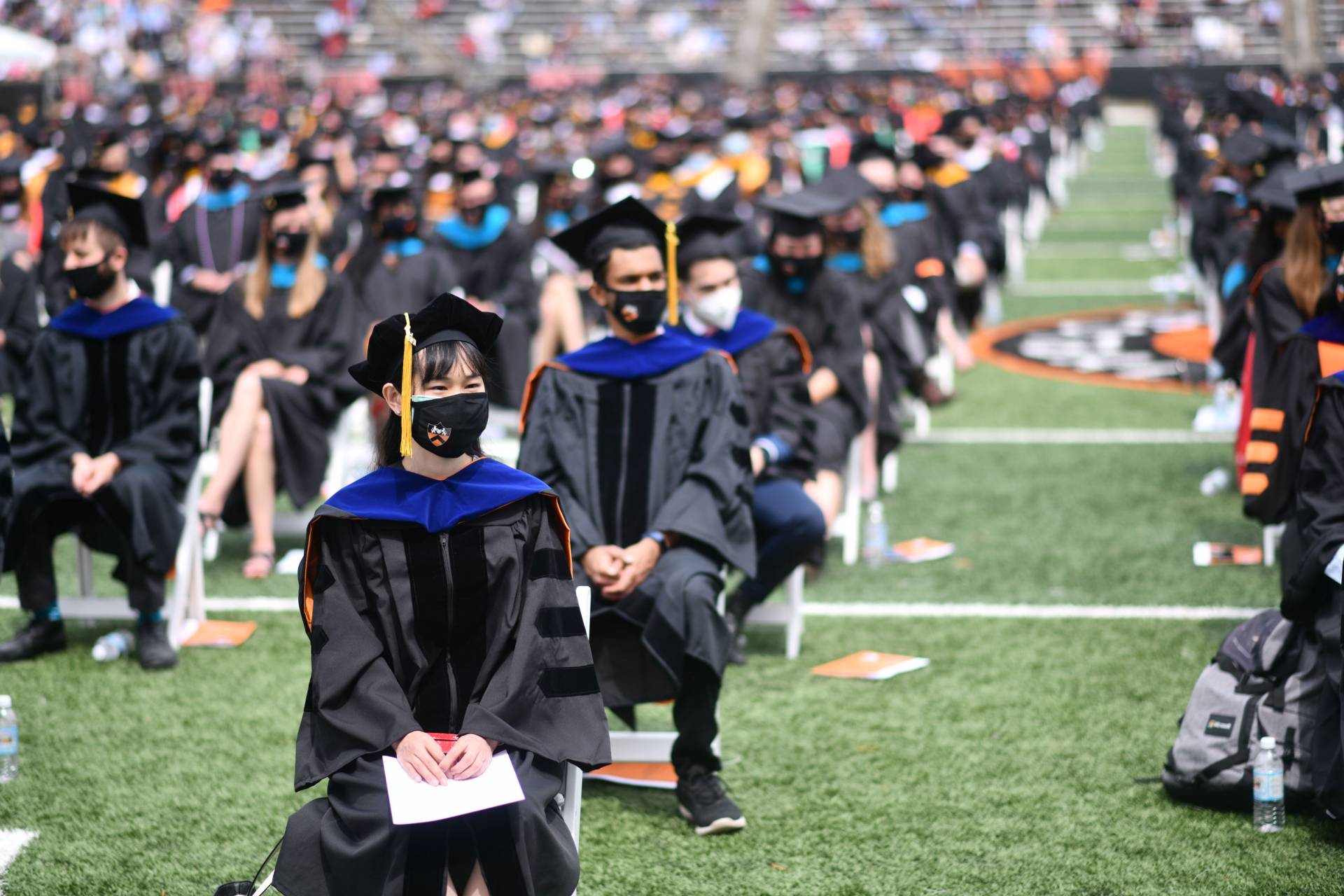 Graduates sit in rows in the stadium