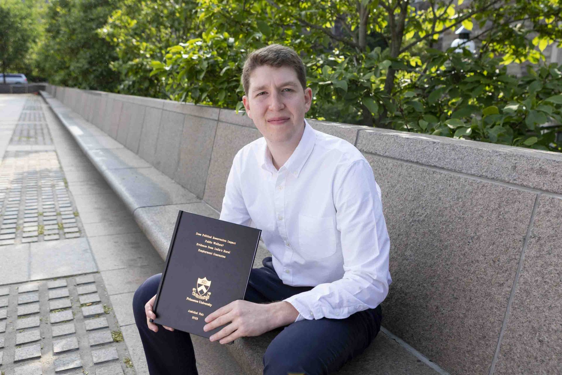 Amichai Feit smiling with his thesis 