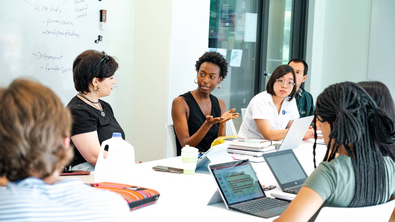 Students having a discussion around a table.