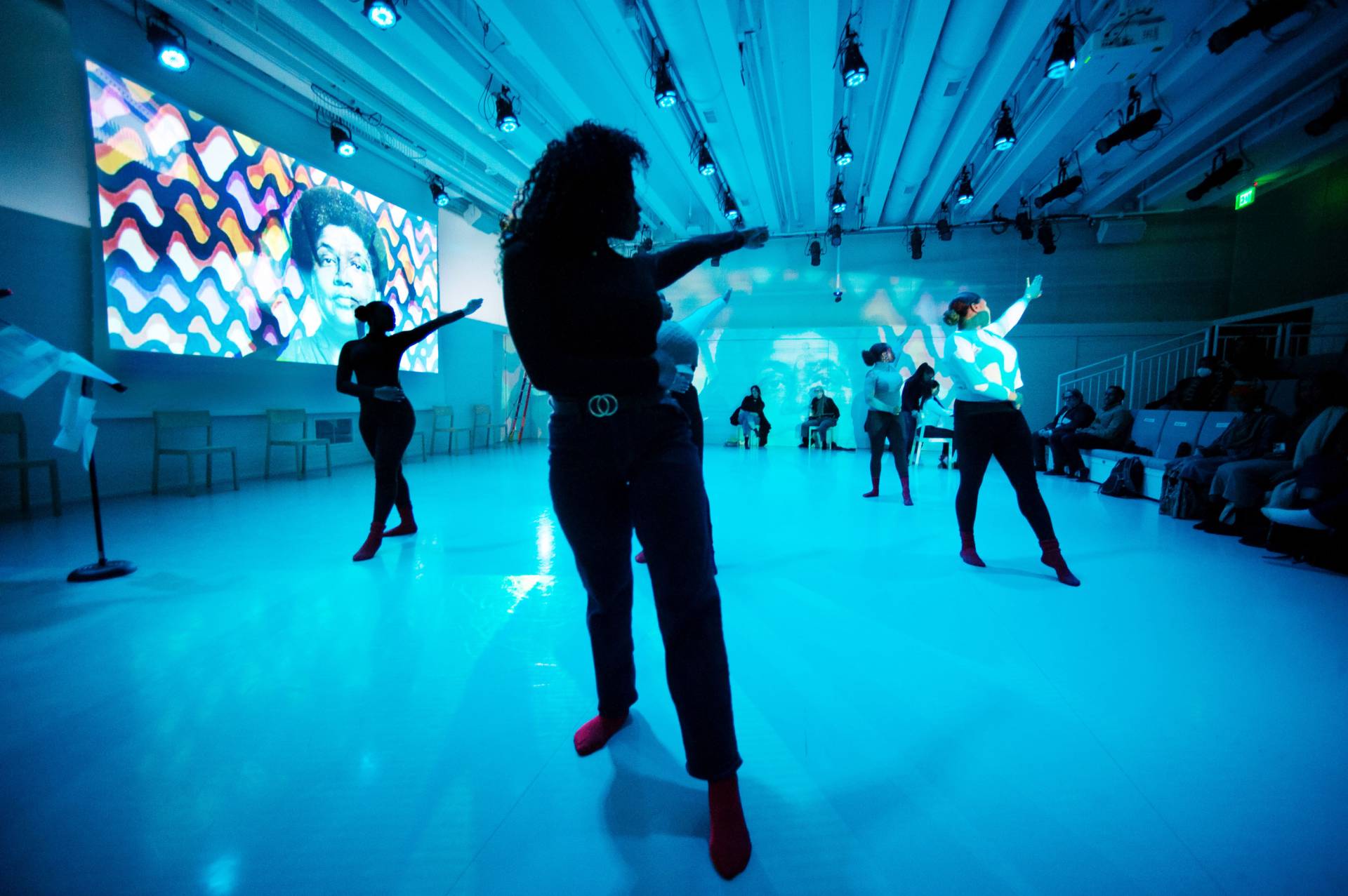 Dancers silhouetted against theatrical lighting