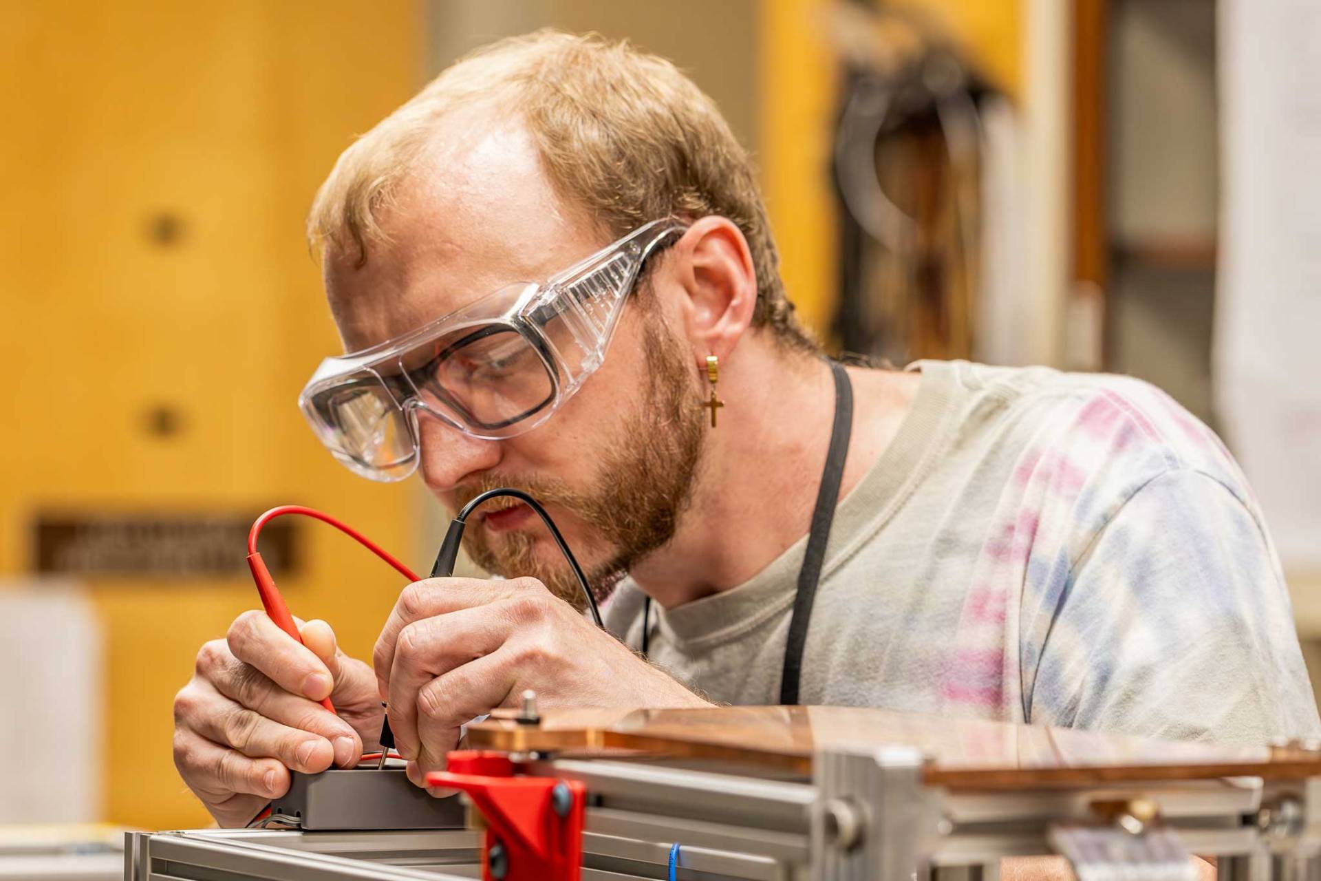 A man uses tools to repair a machine