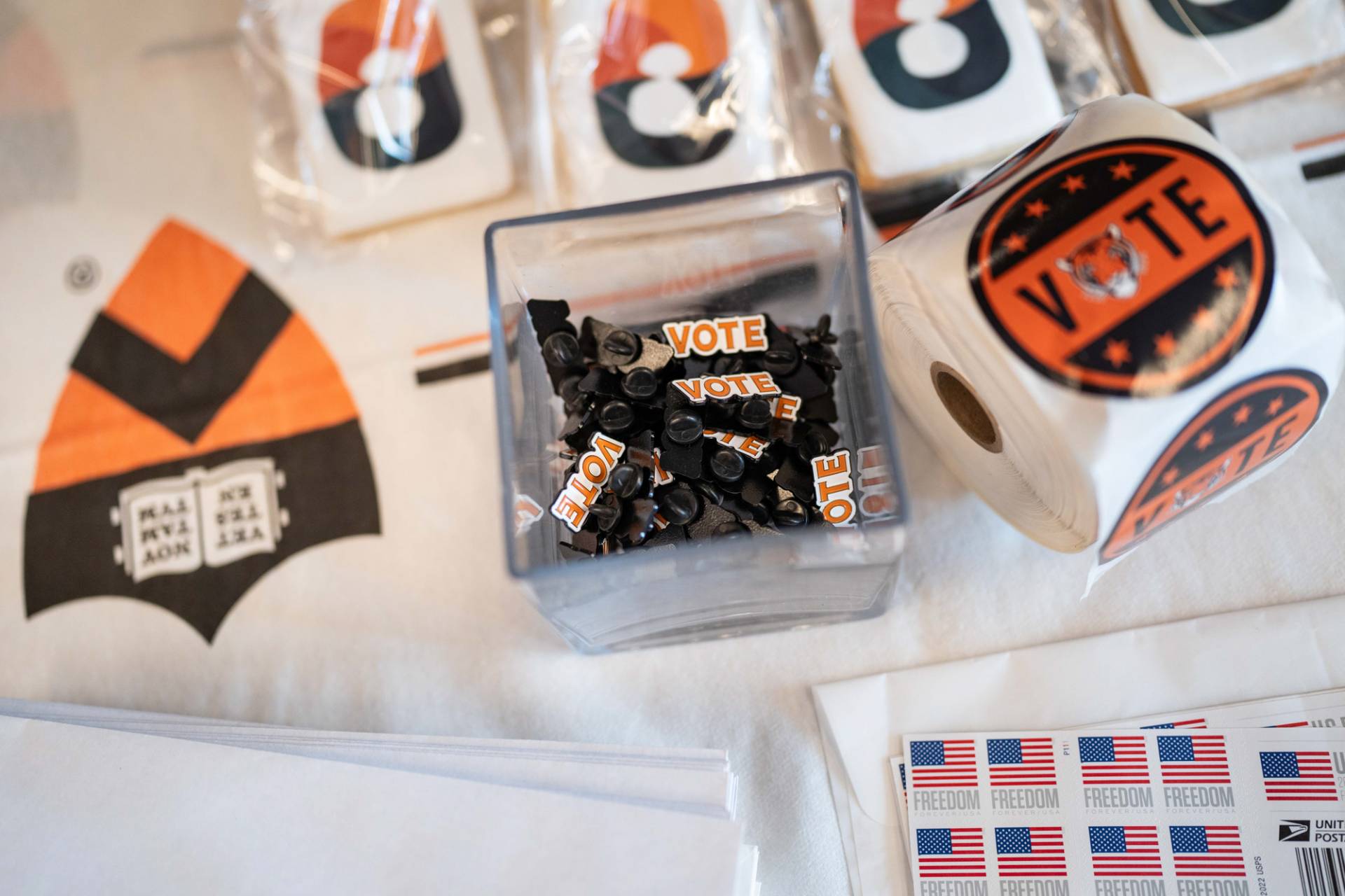 Various items: stickers and pins with the word "Vote". Stamps of the US flag and the word "freedom".