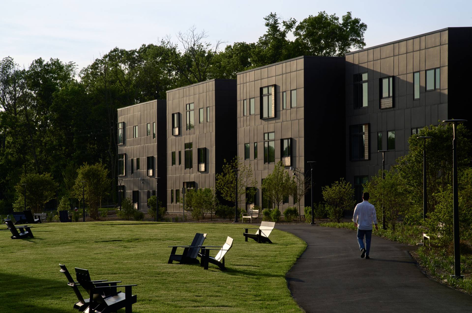 A graduate student walks in front of the Meadows Apartments