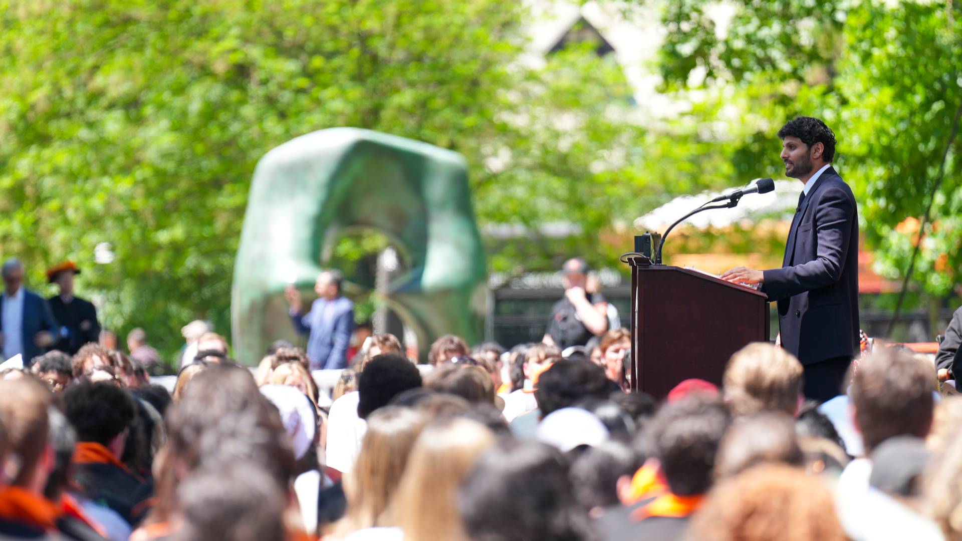 Jay Shetty addresses an audience of students and guests seated on Cannon Green.
