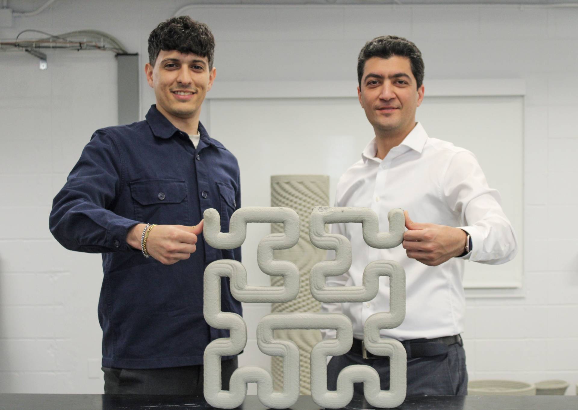 Researchers Reza Moini and Aimane Najmeddine with bone-inspired bricks and other designs for tougher concrete.