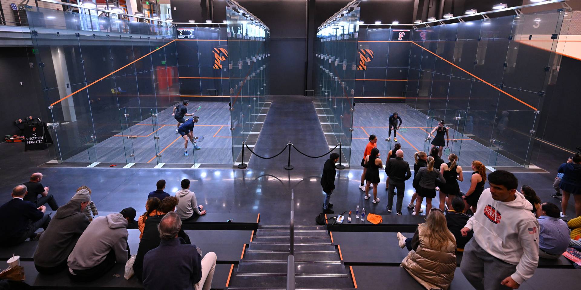 Princeton students play squash as spectators watch