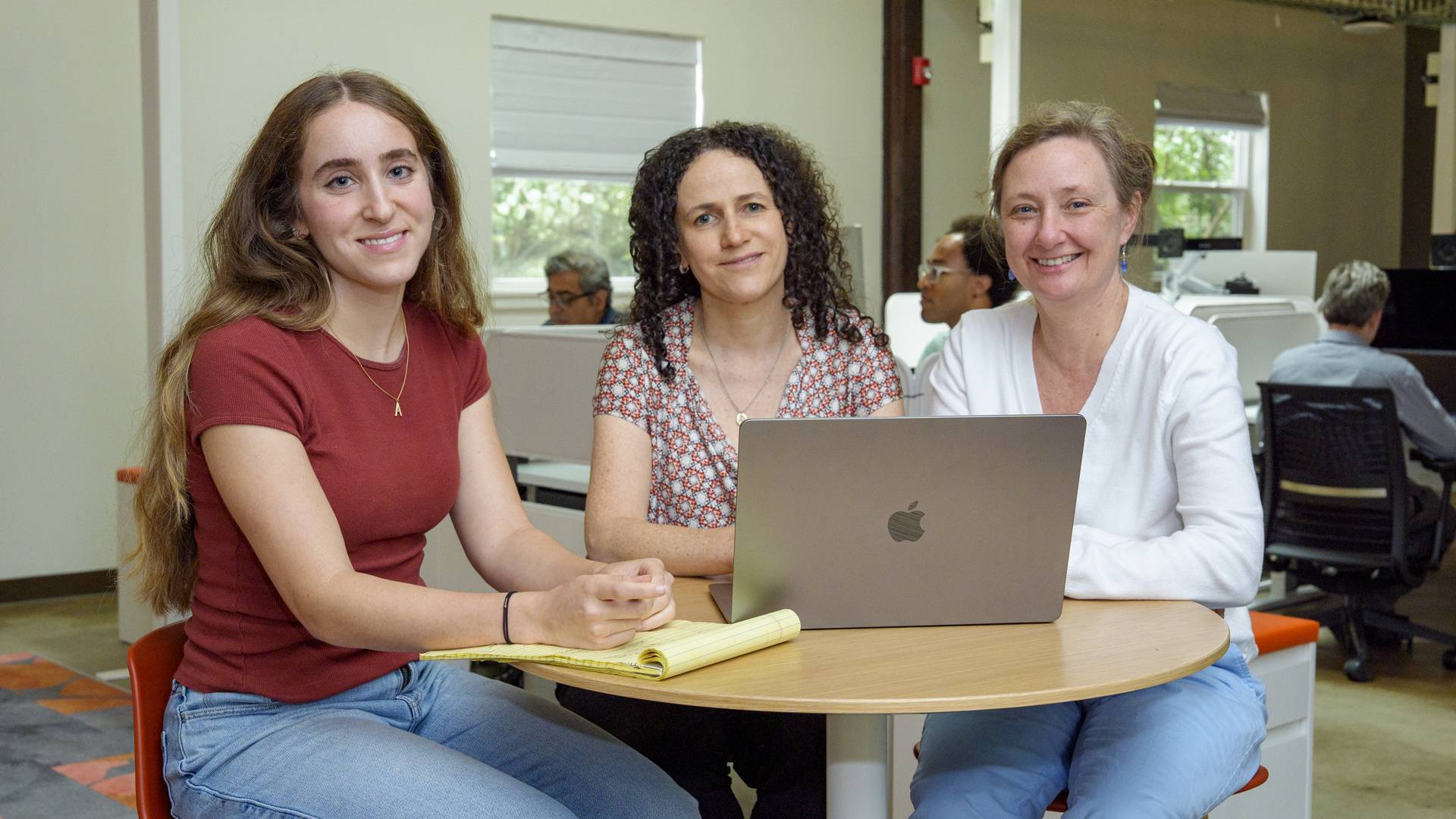 Researchers Aviya Litman, Olga Troyanskaya and Chandra Theesfeld sitting together at a table.