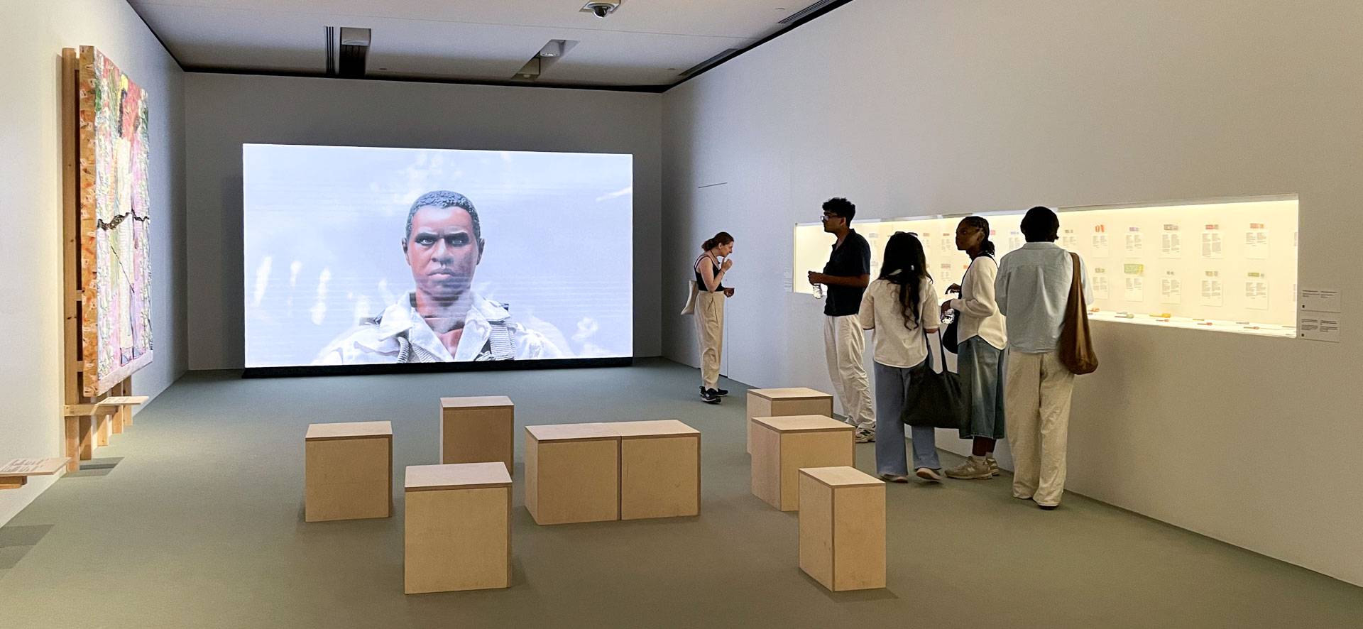 A large image projected on a screen in a museum wing
