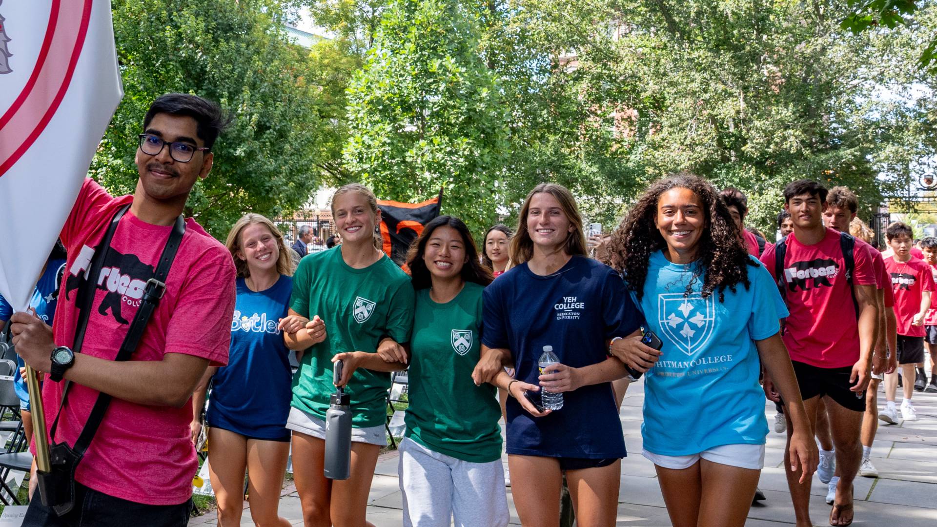 Students walk while linking arms 