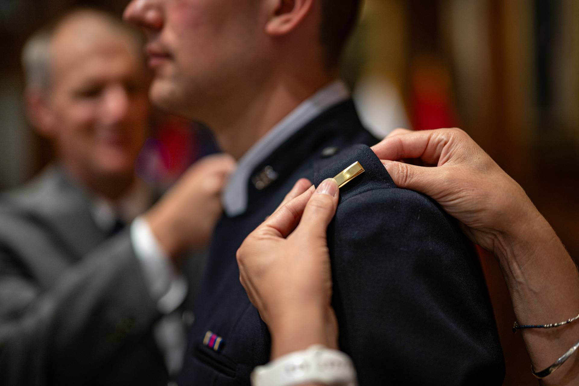 Detail shot of hands attaching ranking pins to an officer's collar