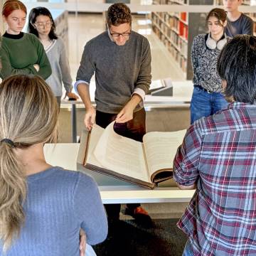 students reviewing a book at library