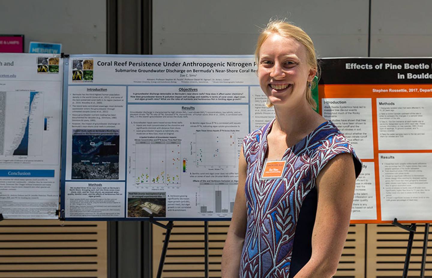 Zoe Sims standing in front of poster