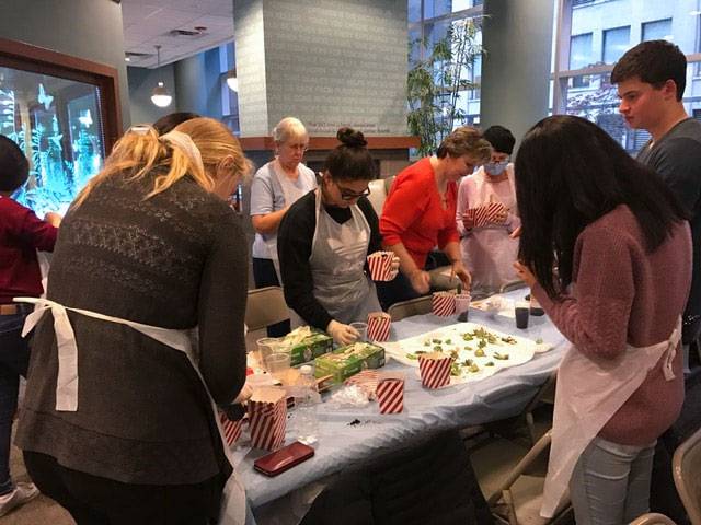 Students working at table potting plants