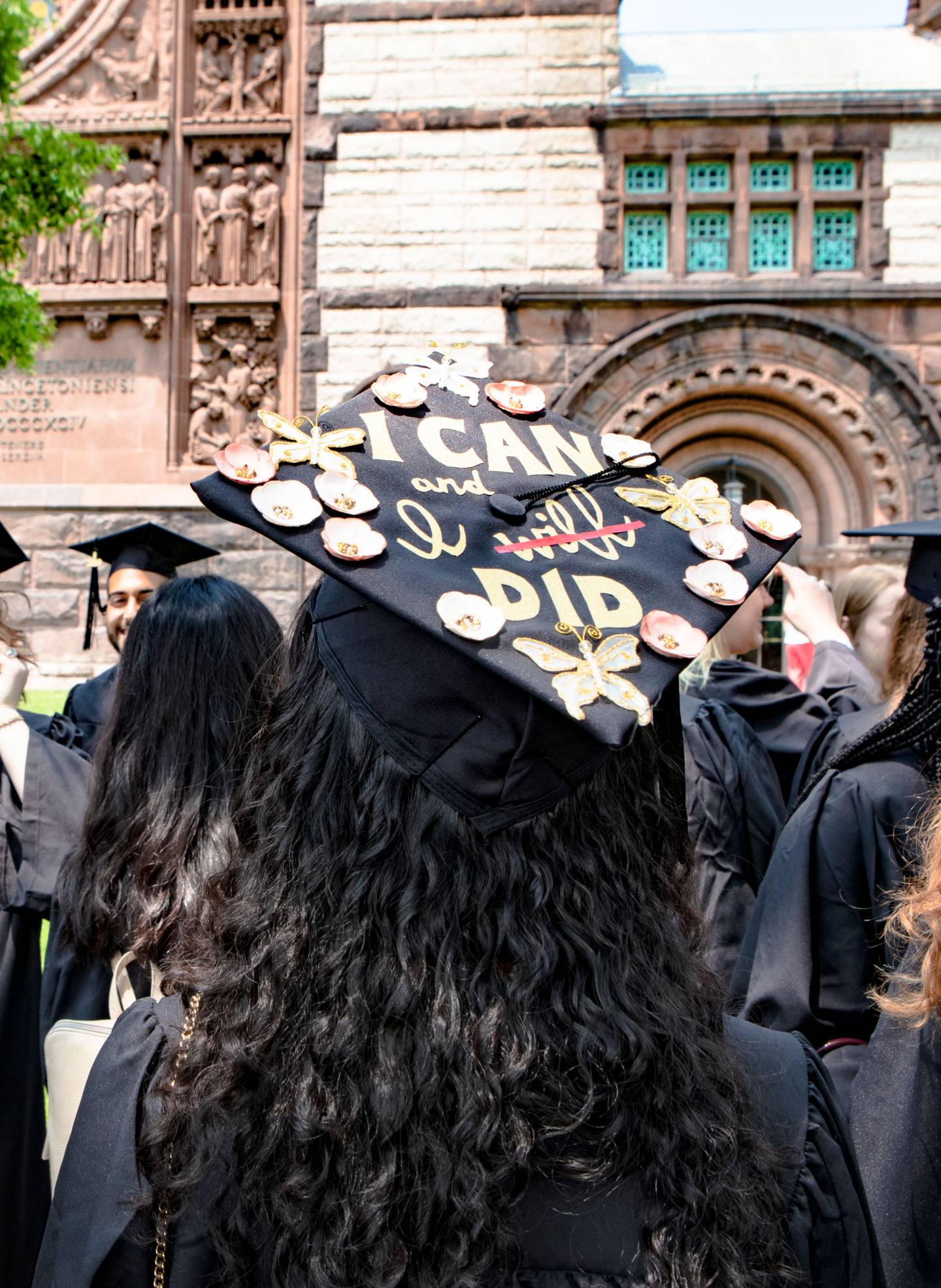 Student showing graduation cap decorated to read "I can and I did"