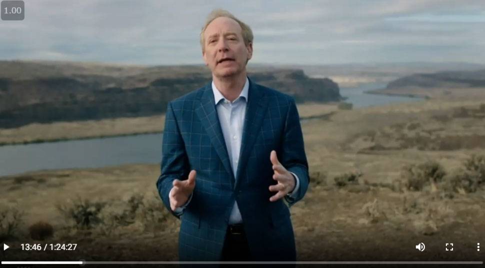 Brad Smith gesticulates while speaking near cliffs