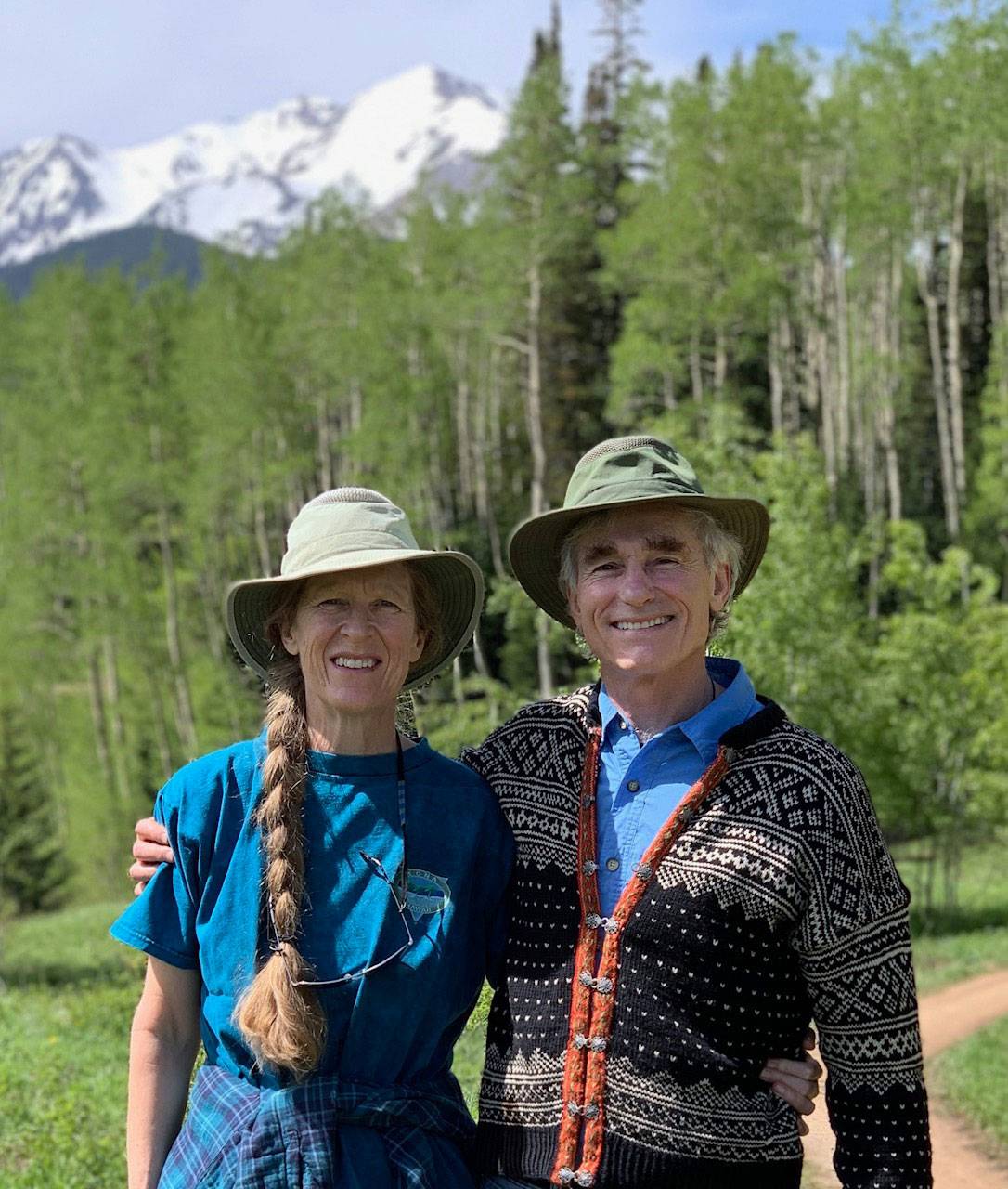 Currie and Tom Barron with pine forest and mountains in the background