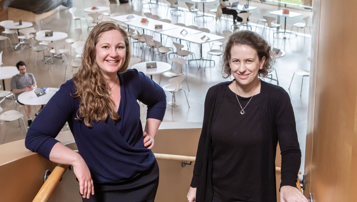 Two researchers in the atrium of the Lewis-Sigler Institute
