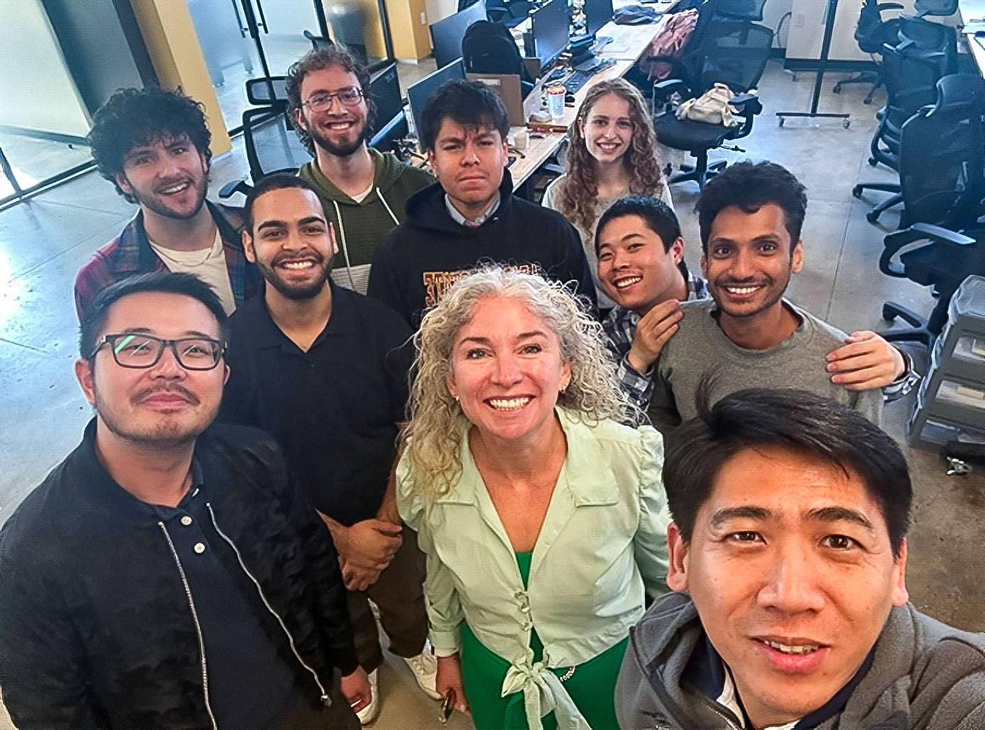 A group of smiling people take a selfie, flanked by Sean Zhang (left) and Jason Ren (right).