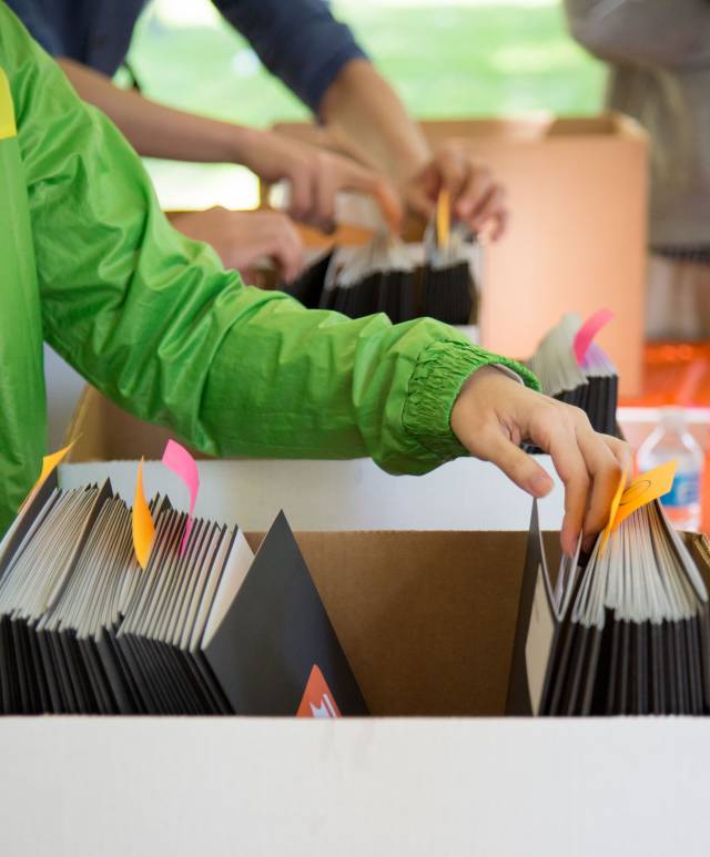 Students look through informational packets at Graduate Student Orientation
