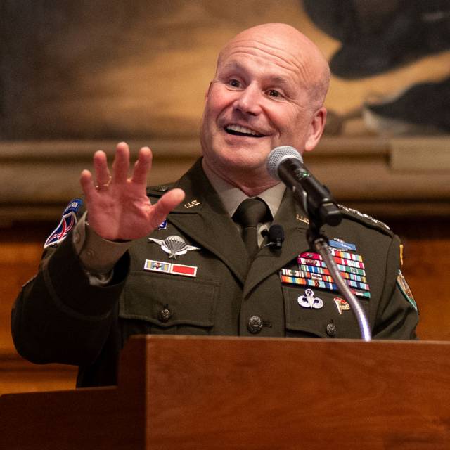 A decorated military general speaks encouragingly from the podium.